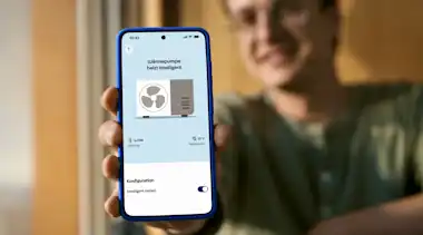 Mann zeigt Handyscreen für Wärmepumpenlösung