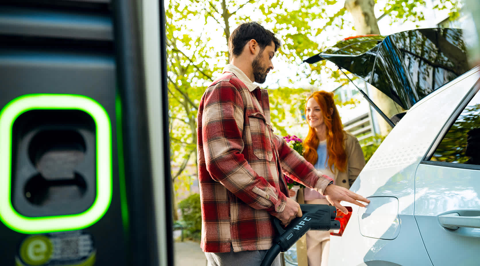 Paar lädt E-Auto an einer EnBW-Schnellladestation