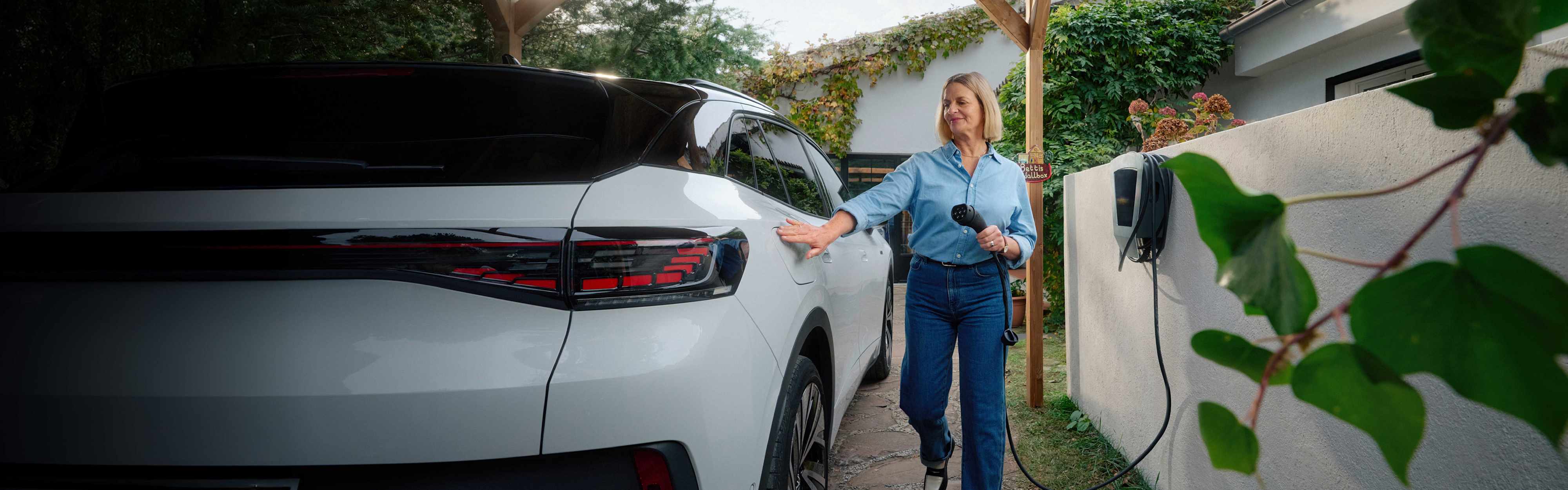 Kampagne Frau mit Wallbox an ihrem Auto