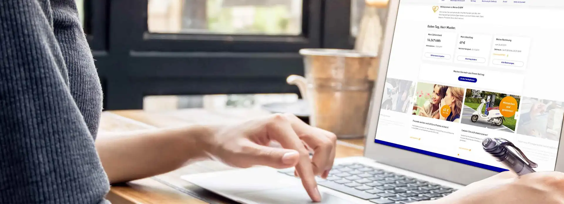 Finger von Frauenhand tippt auf Mousepad Laptop Meine EnBW Website