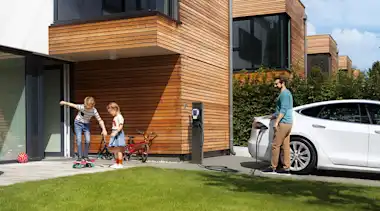 Mann tankt das E-Auto zu Hause auf