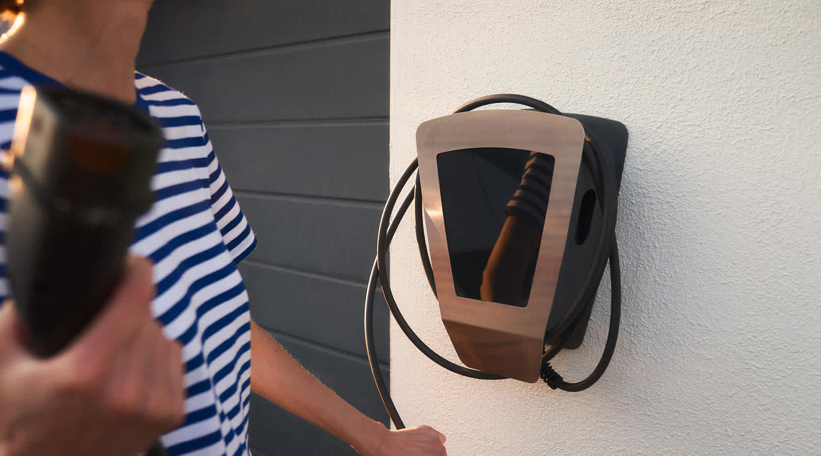 Frau lädt E-Auto an der EnBW Wallbox zu Hause