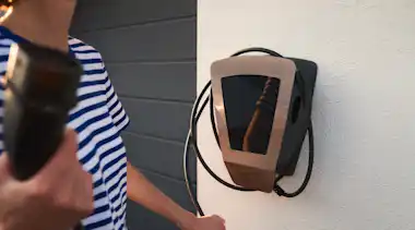 Frau lädt E-Auto an der EnBW Wallbox zu Hause