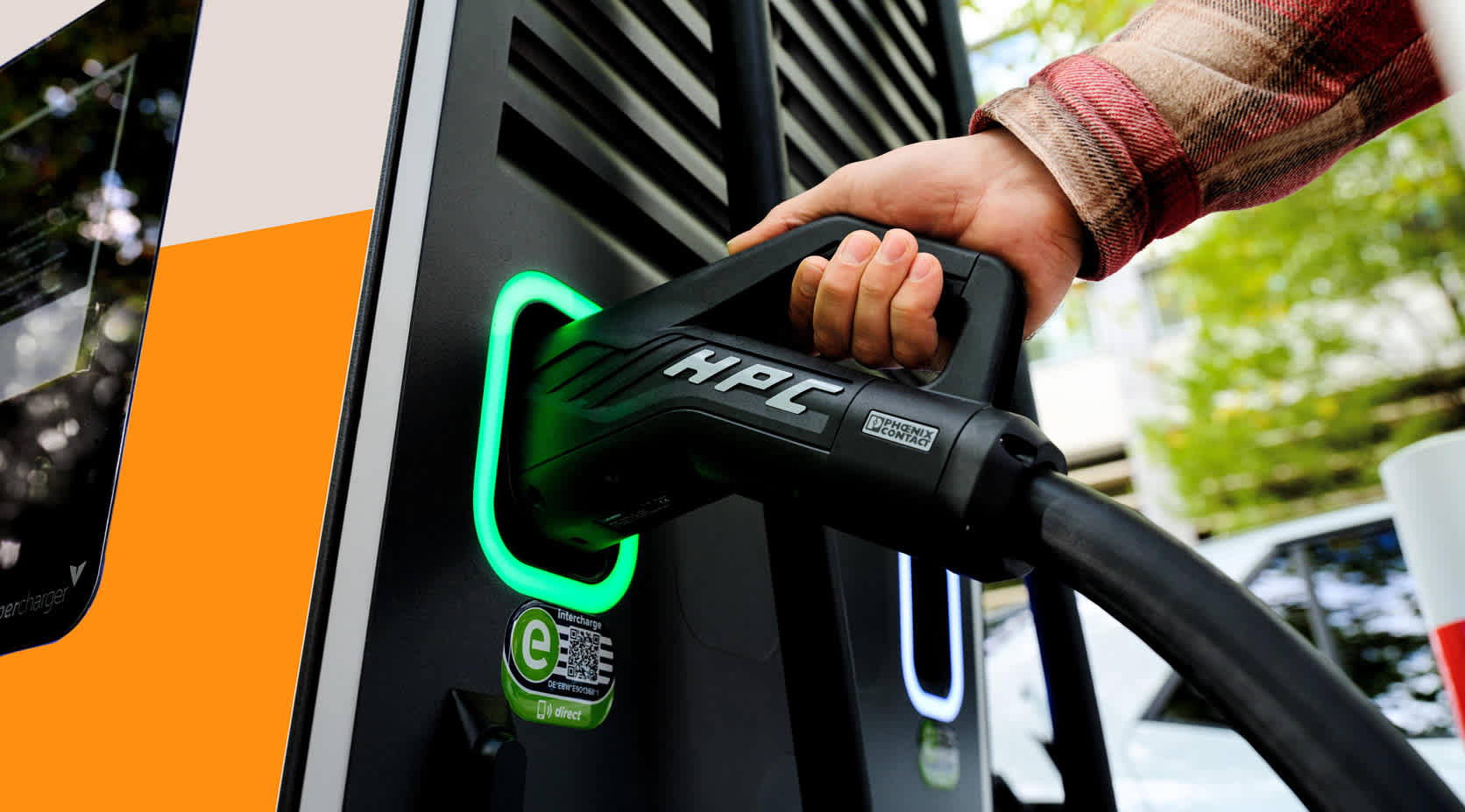 Hand greift zu Charger in Ladestation