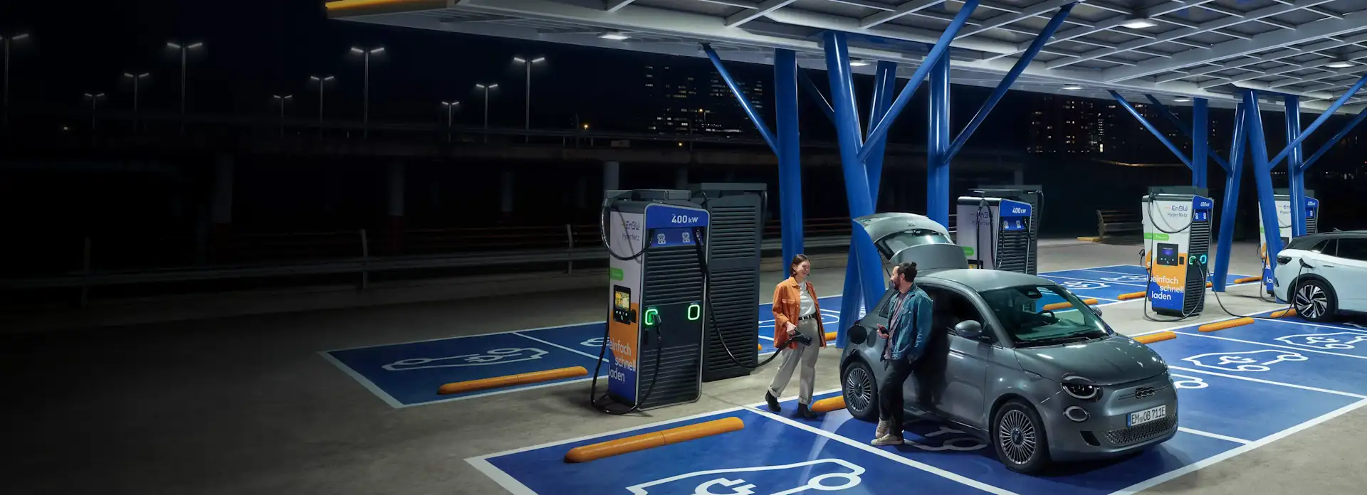 Ein Pärchen lädt sein Auto in einem EnBW Ladepark.