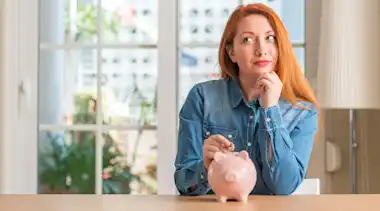 Frau steckt eingesparte Stromkosten ins Sparschwein