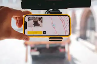 Handy unter dem Rückspiegel befestigt. Zeigt App Screen vom intelligenten Straßenmanagementsystem vialytics , das den Zustand Ihrer Infrastruktur erfasst