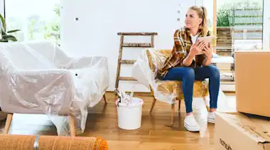 Frau sitzt auf Stuhl beim Umzug in die neue Wohnung