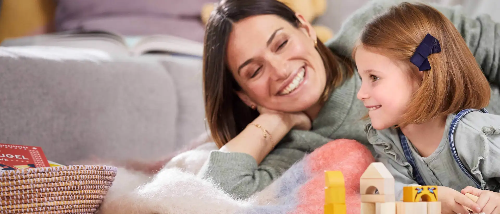 Mutter und Tochter spielen mit Bauklötzen auf dem Boden