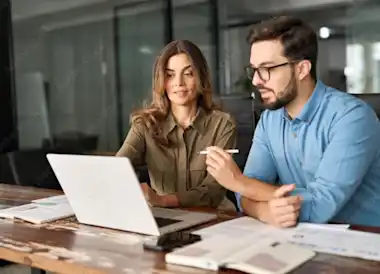 Mann und Frau schauen auf den Bildschirm eines Laptops