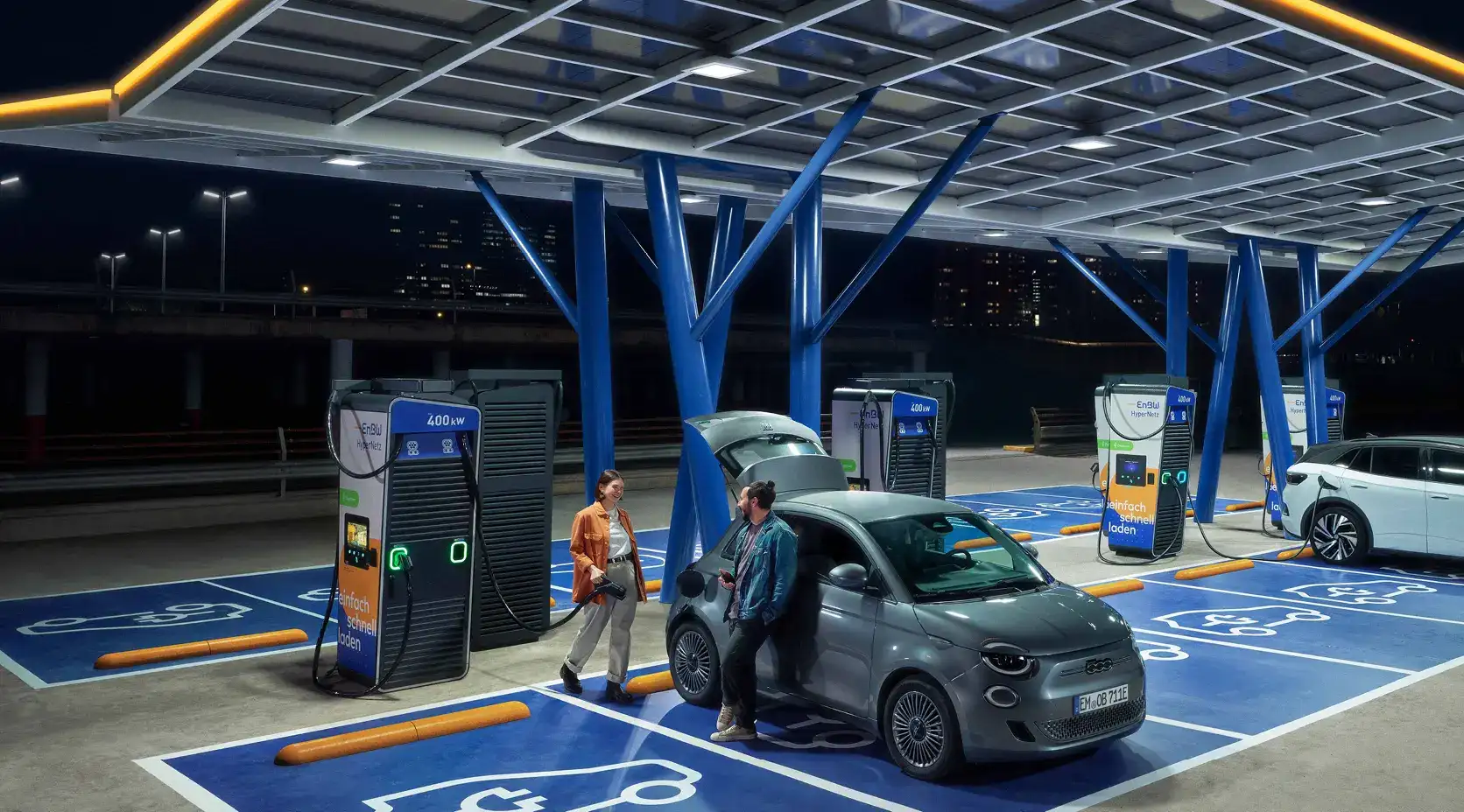 Ein Pärchen lädt sein Auto in einem EnBW Ladepark.