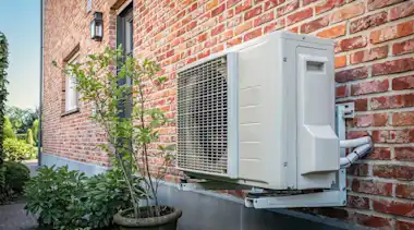 Wärmepumpe an der Hauswand eines alten Bestandsgebäudes