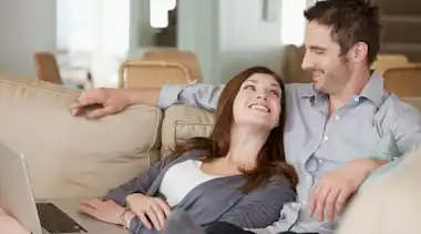 Paar auf Couch freut sich über Wechsel zur EnBW
