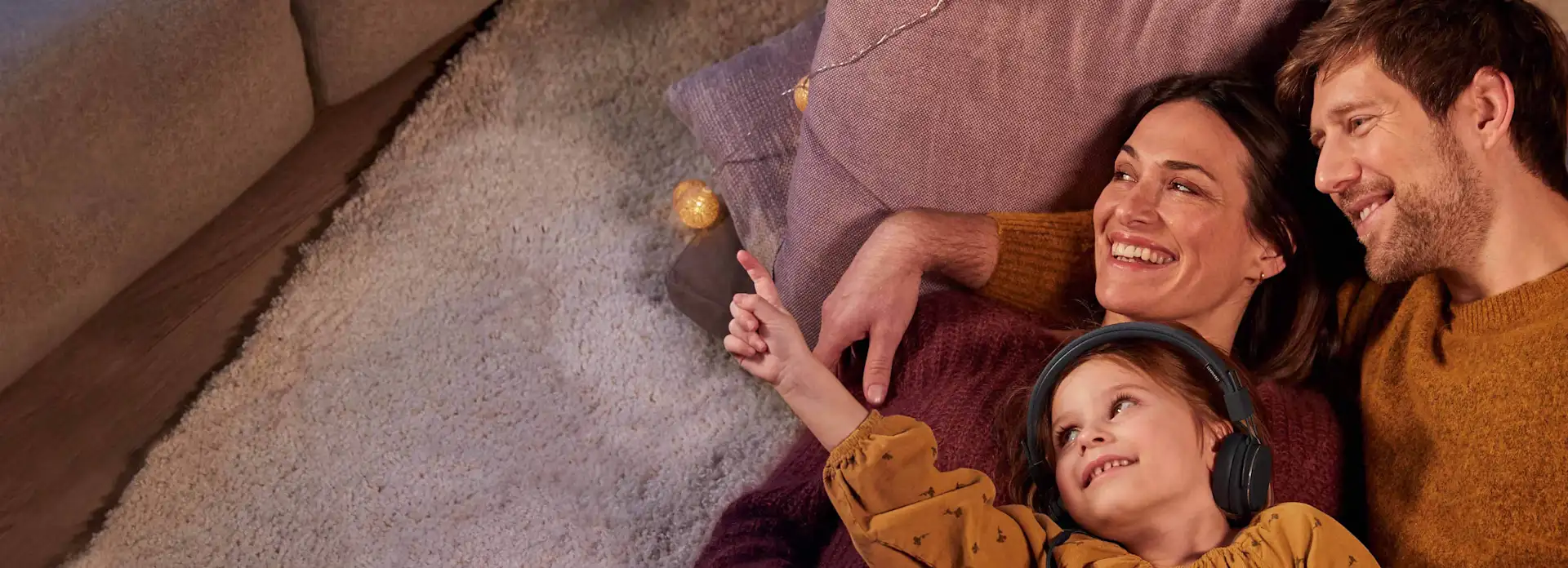 Familie kuschelt auf dem Boden mit Lichterkette