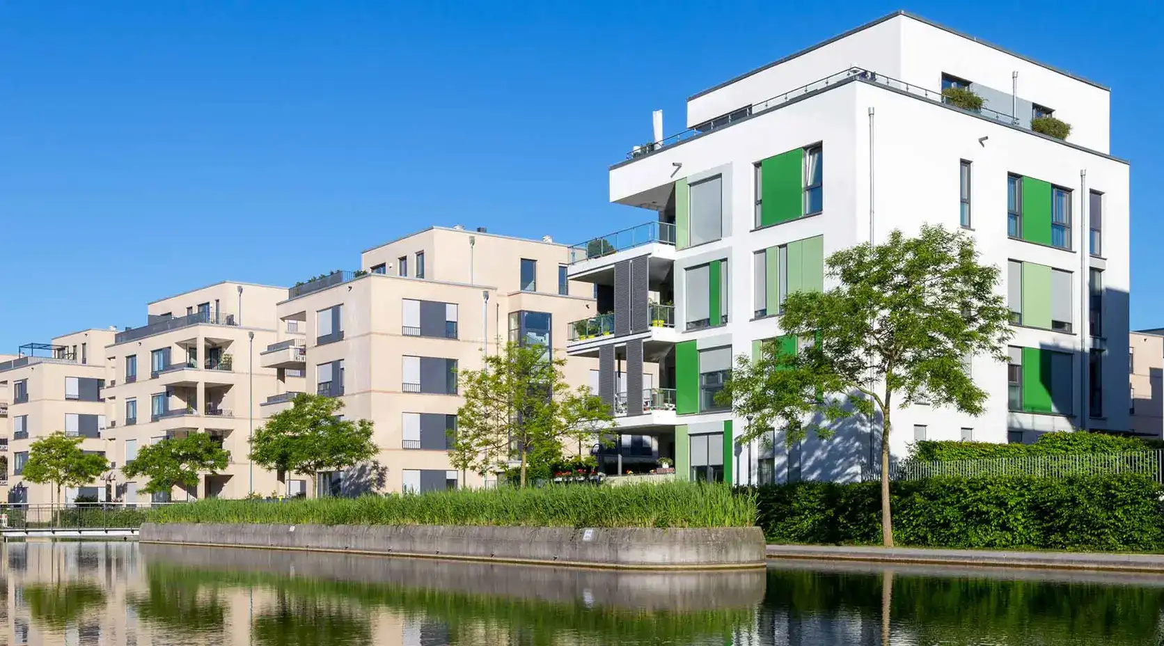 Eine Wohngegend mit modernen und neu gebauten Hochhäusern direkt an einem See/Fluss