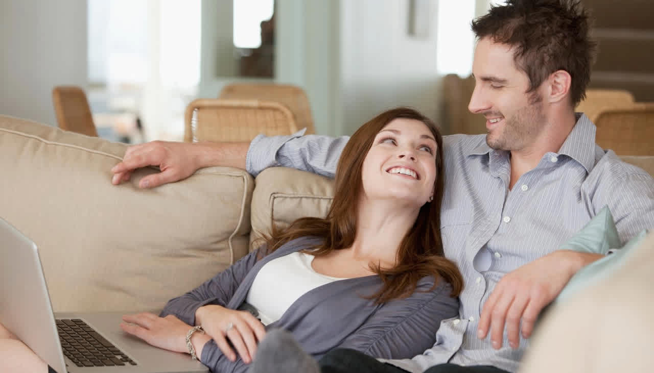Paar auf Couch freut sich über Wechsel zur EnBW