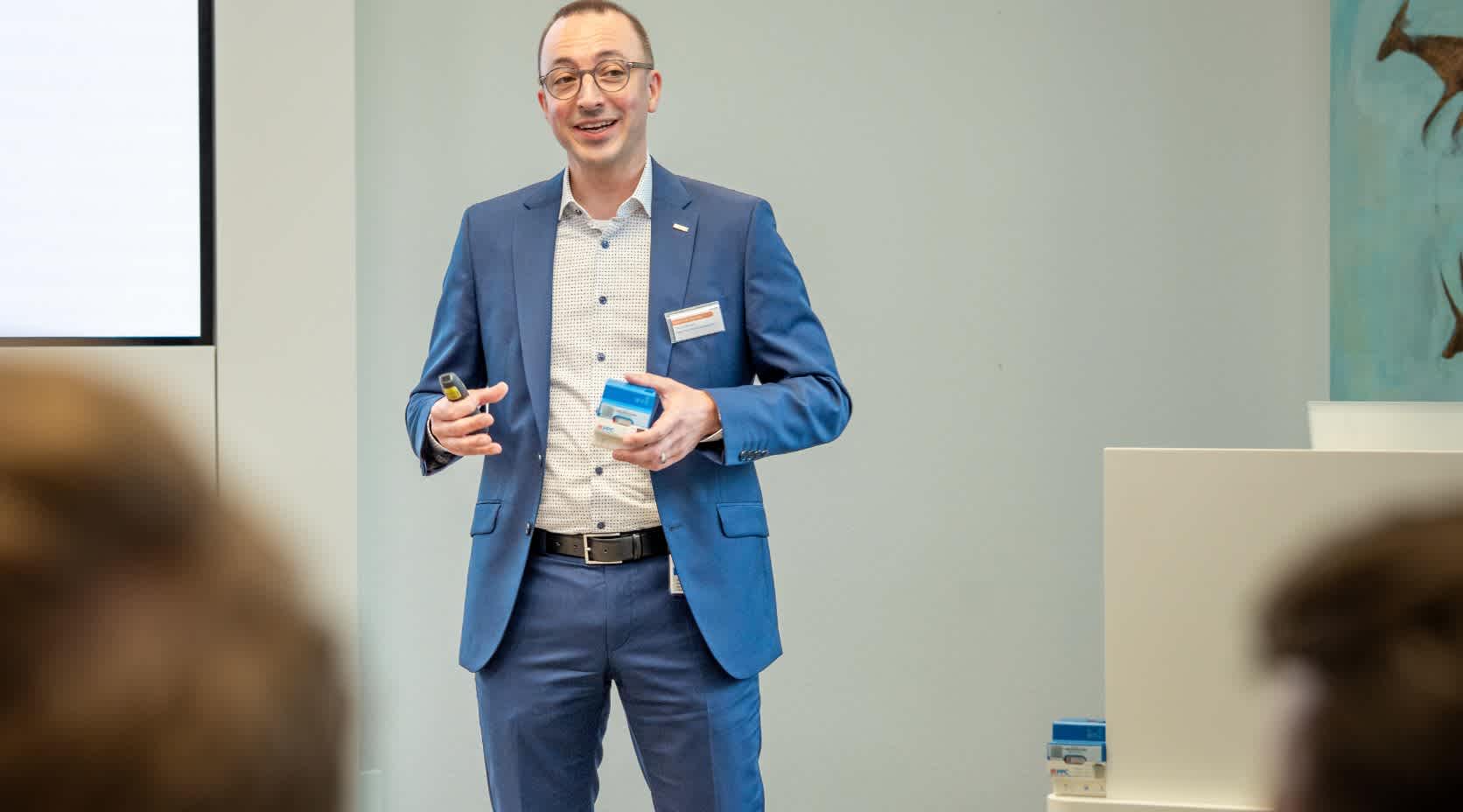 Mann in Anzug gibt einen Vortrag