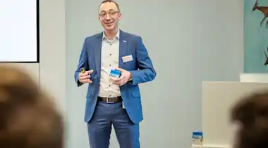 Mann in Anzug gibt einen Vortrag