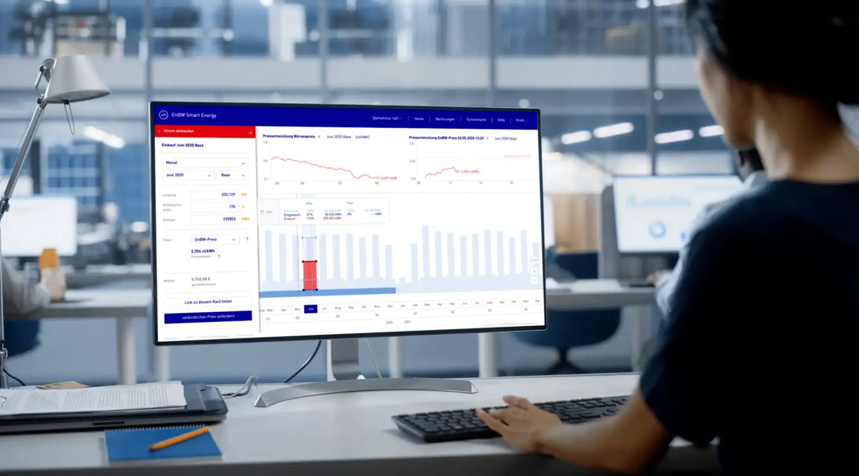Dunkelhaarige Frau am Computer-Desktop mit Diagrammen und Grafiken von Smart Energy