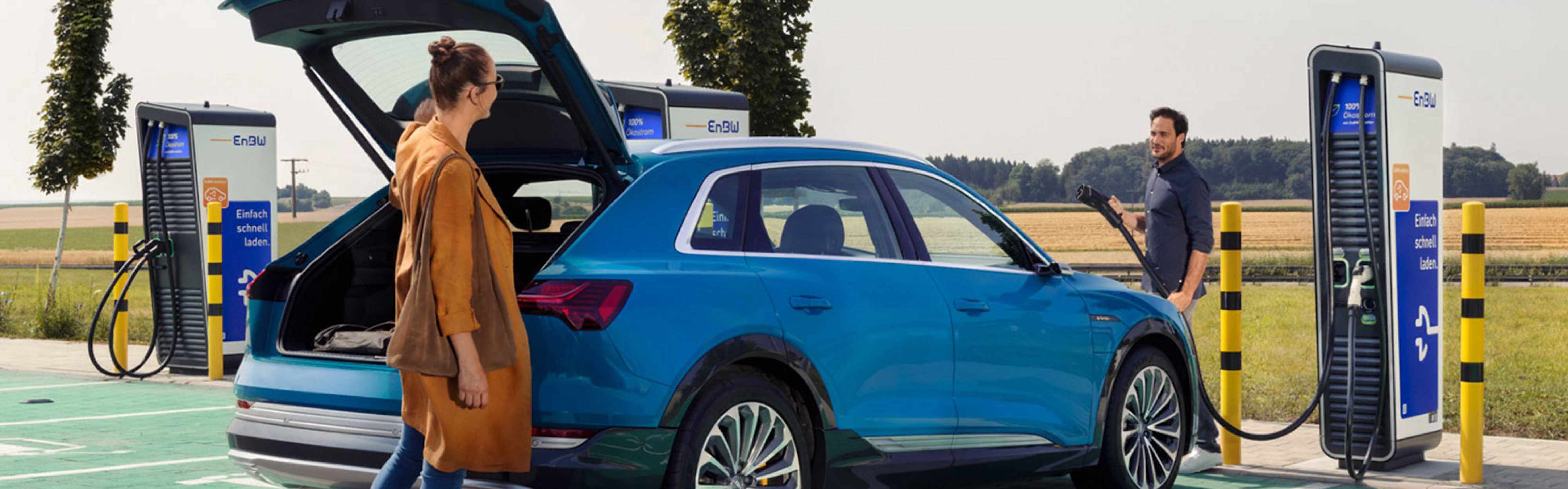 Pärchen auf dem Parkplatz beim Laden ihres Autos