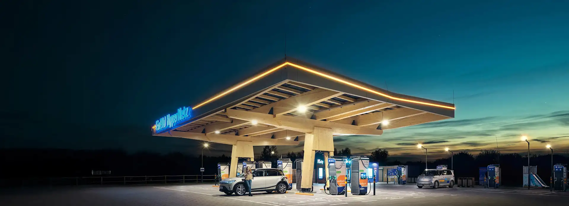 EnBW HyperNetz Ladepark Chemnitz bei Nacht Frau Elektroauto