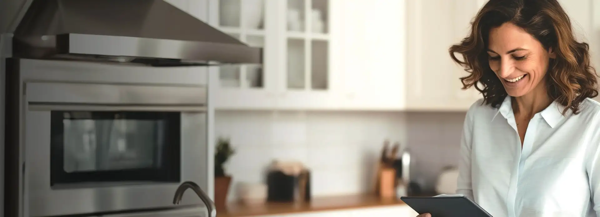 Lächelnde Frau mit Tablet in der Küche