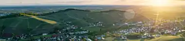 Blick Vogelperspektive auf Dorf mit vielen Feldern und strahlender Sonne