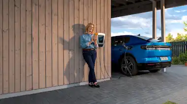 EnBW Frau Ladestation Elektroauto Wallbox Carport Smartphone Ausrichtung mittig