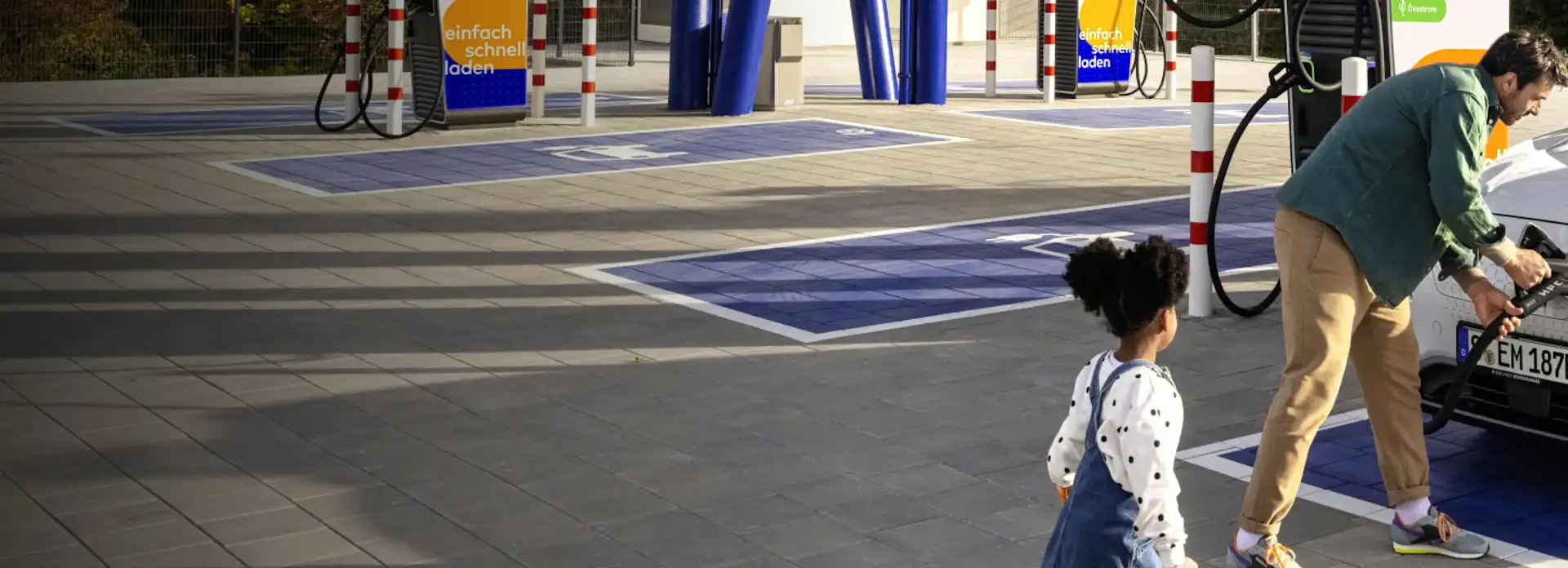 Vater lädt E-Auto in EnBW Ladepark