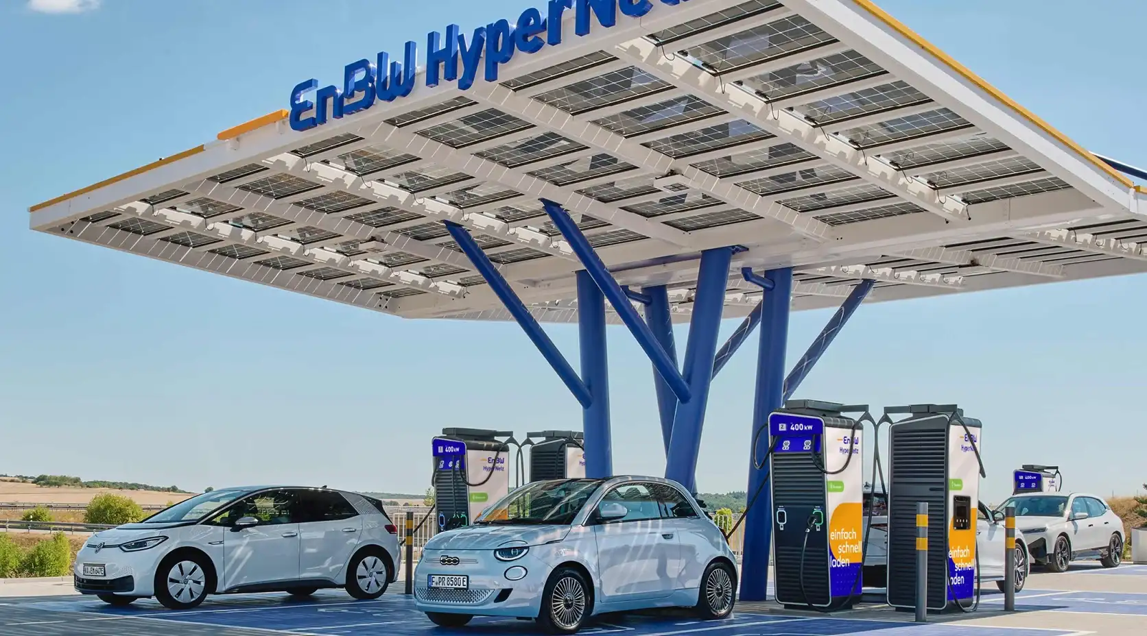 EnBW Hypernetz Ladepark weiße Elektroautos am Laden blauer Himmel