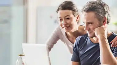 Zufriedene EnBW Kunden sitzen am Laptop