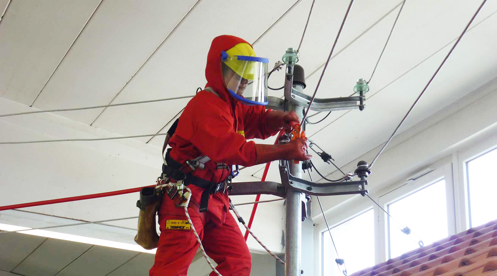 Netze-Mitarbeiterin steht auf einem Dach und repariert das Stromnetz