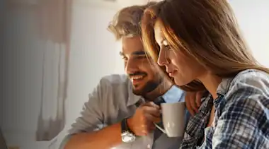 Braunhaarige Frau und Mann am Laptop Paar karierte Bluse