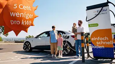 Familie steht an einer EnBW-Ladestation vor ihrem E-Auto. Neben ihnen fliegt ein Luftballon in Form einer Sonne mit der Aufschrift "5 Cent weniger pro kWh".
