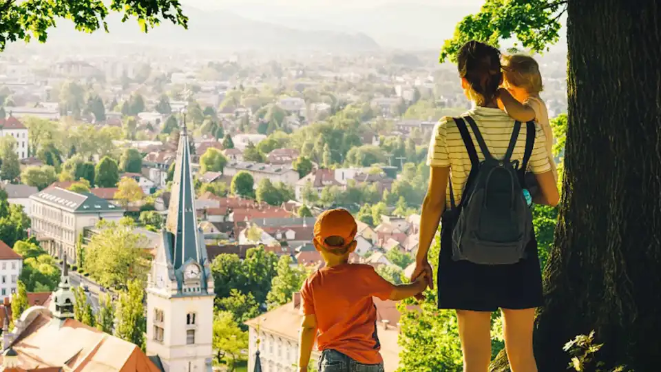 Frau mit Kindern blickt auf eine Stadt