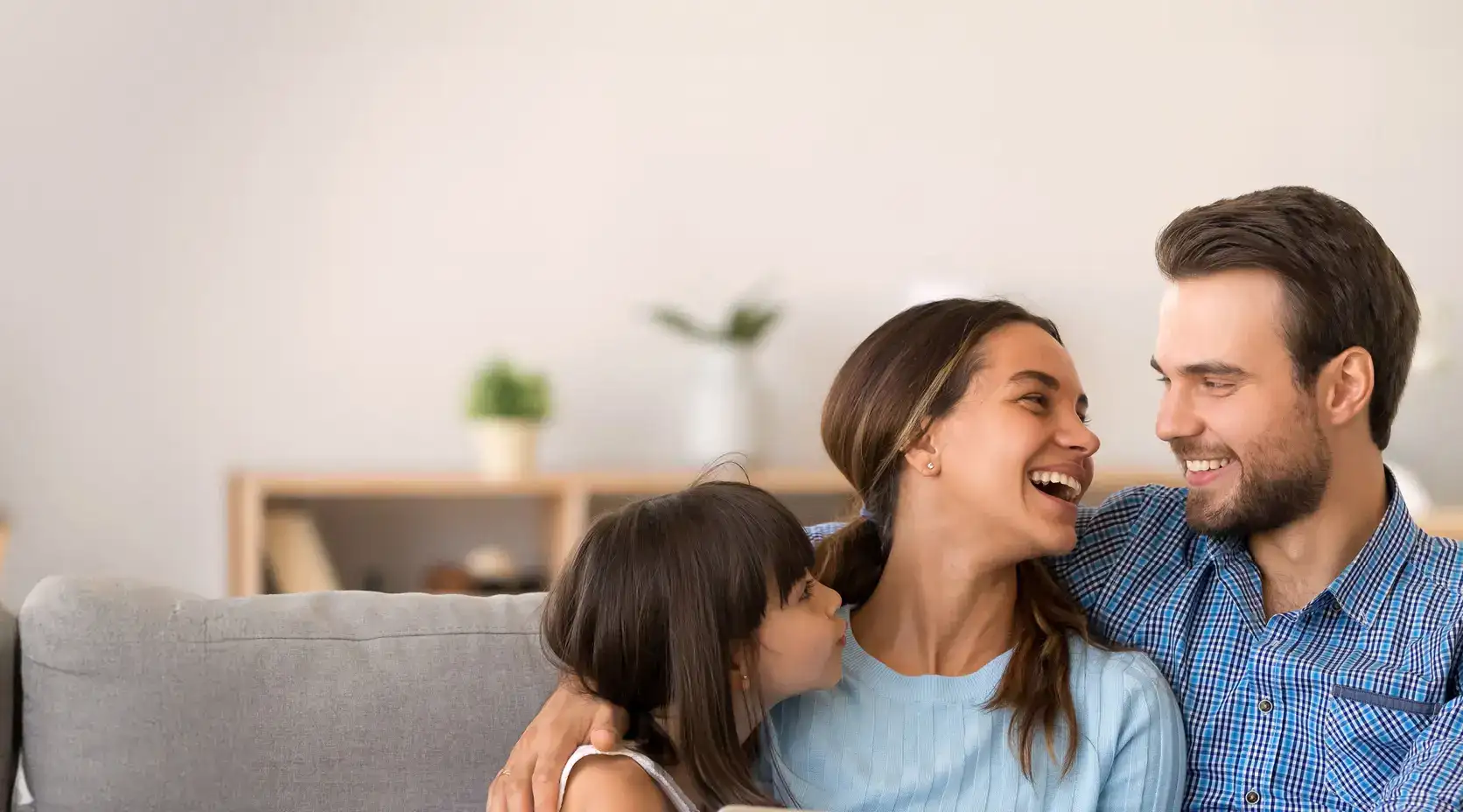 Familie sitzt auf dem Sofa und freut sich