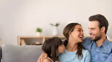 Familie sitzt auf dem Sofa und freut sich