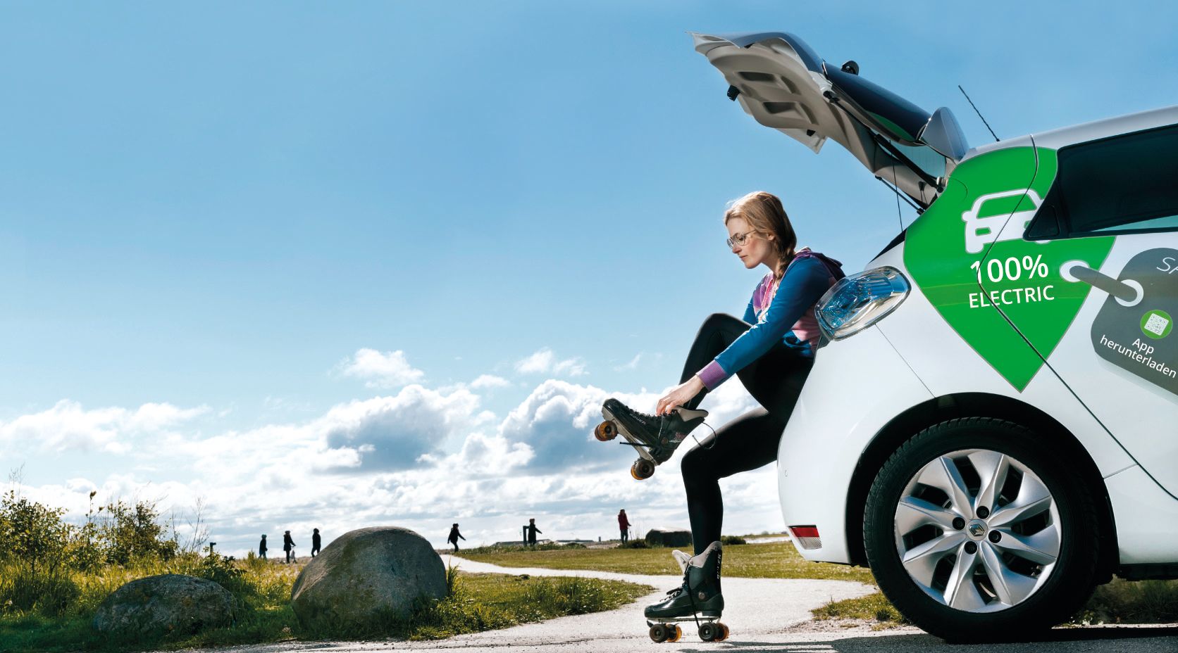 Frau mit E-Auto zieht Rollschuhe im Freien an