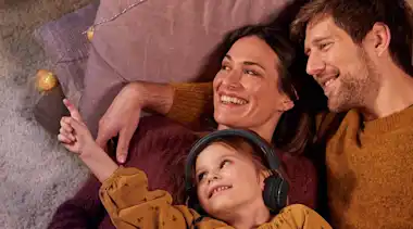 Familie kuschelt auf dem Boden mit Lichterkette