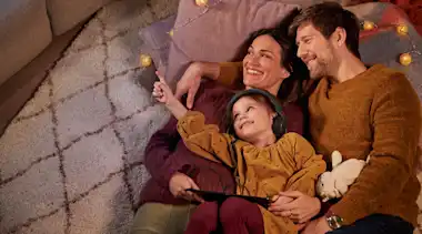 Familie liegt auf dem Teppichboden