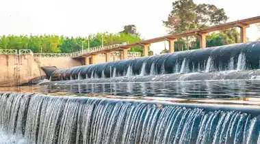 Wasserkraftwerk mit Beton-Stauwehr Konstruktion nutzt Seitenkanal und Überlaufvorrichtung