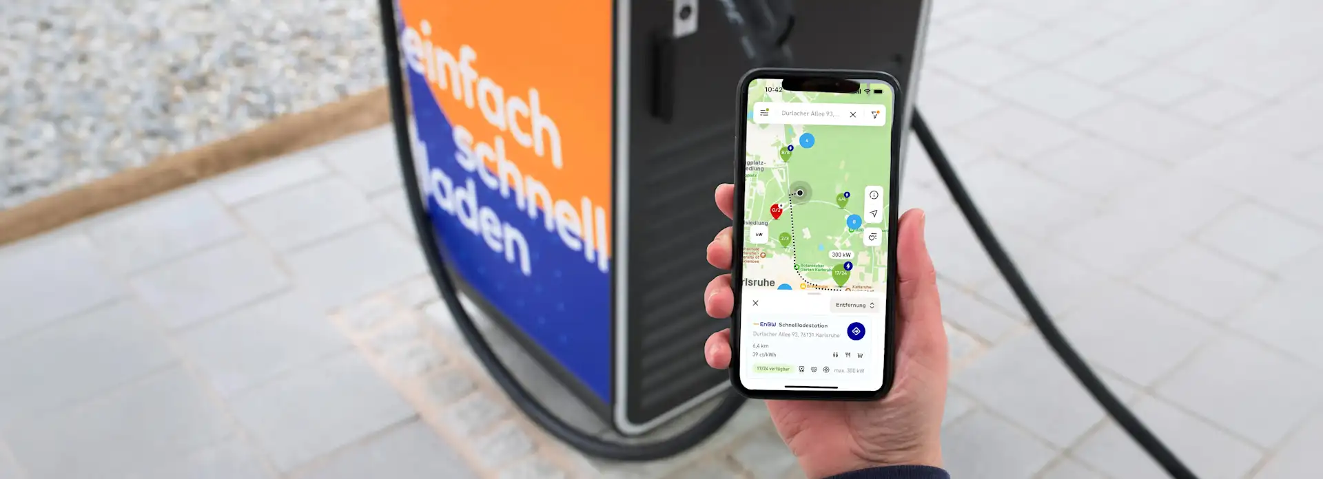 Mensch bezahlt mit mobility+ App vor einer Ladesäule