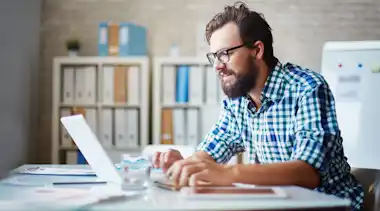 Mann schaut auf Laptop