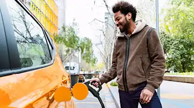 Mann tankt an E-Auto