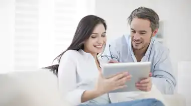 Pärchen schaut auf Tablet etwas nach