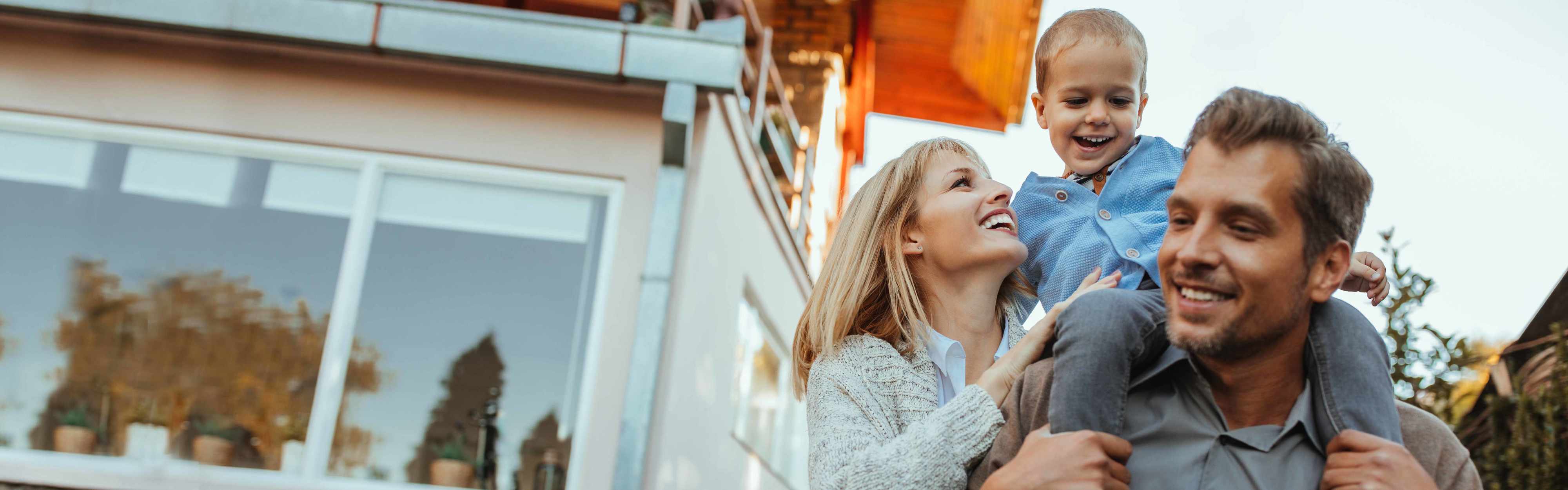 Fröhliche Familie vor ihrem Haus