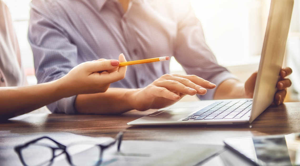 Mann und Frau besprechen Projekt vor Notebook