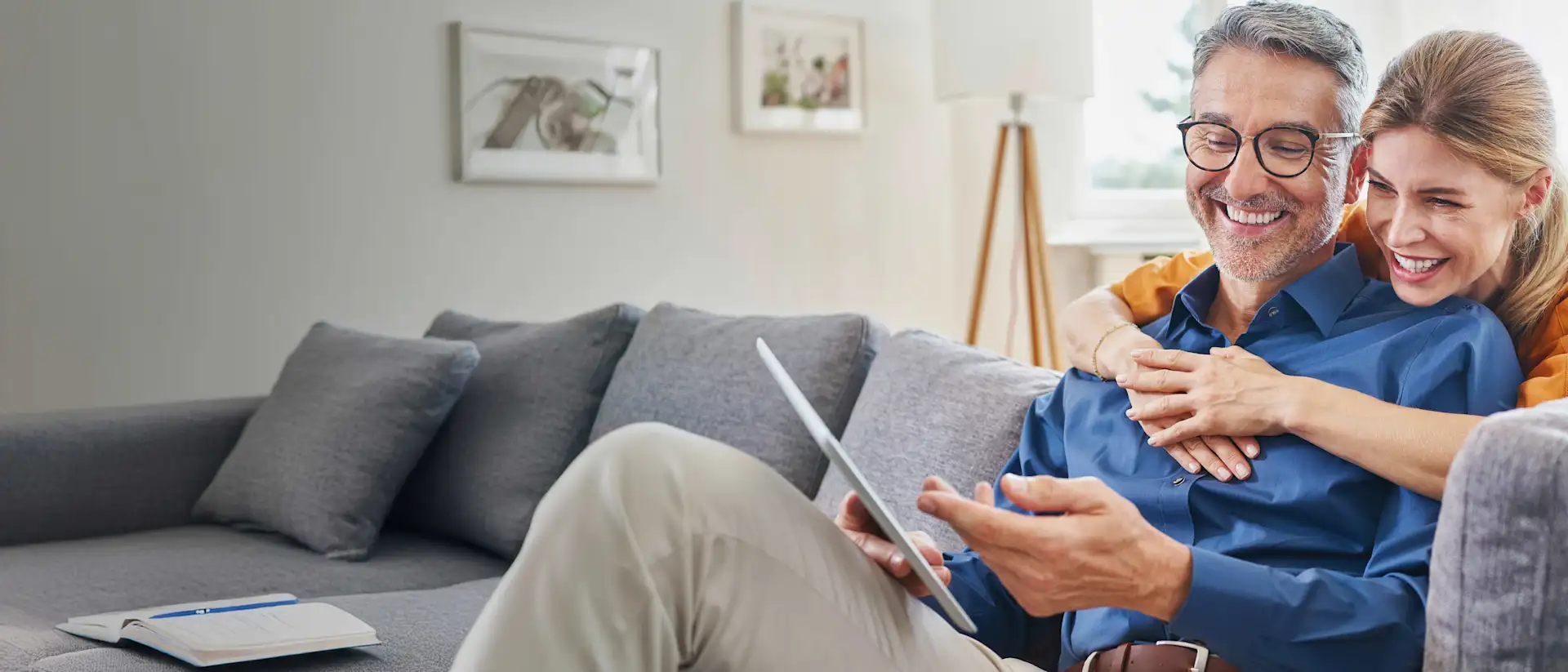 Mann und Frau auf der Couch mit einem Tablett.