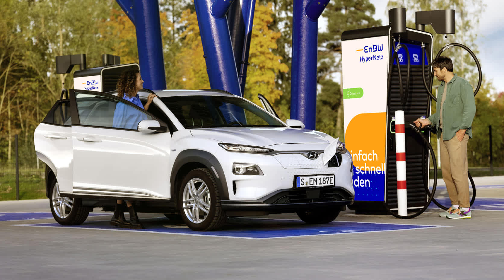 Paar lädt E-Auto an einer EnBW-Ladestation