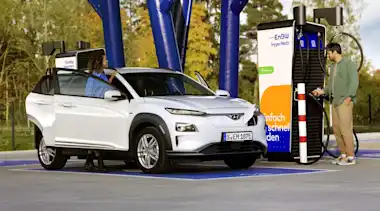 Paar lädt E-Auto an einer EnBW-Ladestation